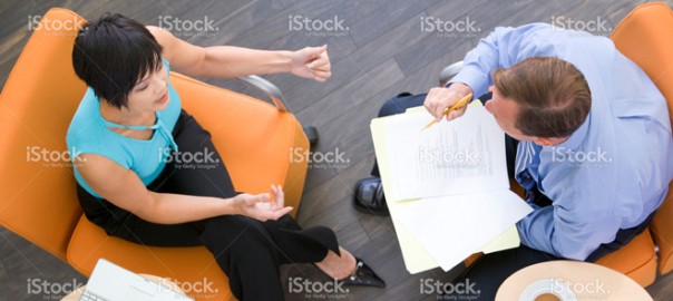 Two professionals in business meeting reviewing documents