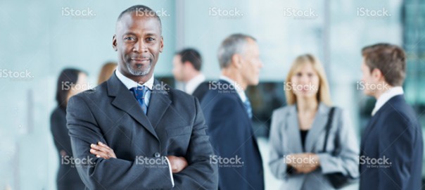 Confident businessman standing with colleagues in office