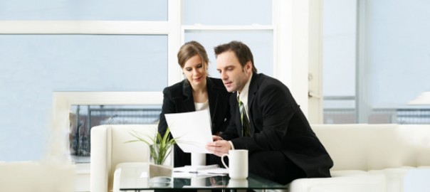 Business colleagues reviewing documents on couch