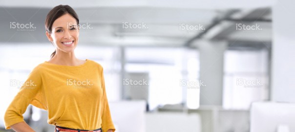 Smiling woman in yellow sweater in office