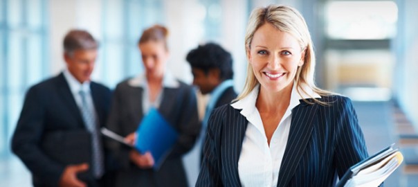 Smiling businesswoman holding documents with colleagues in office