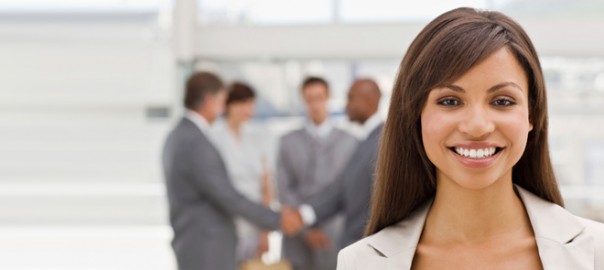Smiling businesswoman with colleagues shaking hands