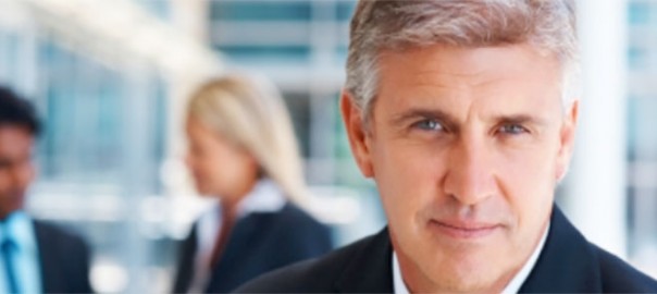 Confident businessman portrait with blurred colleagues