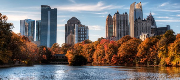 City skyline reflecting in pond amid autumn foliage