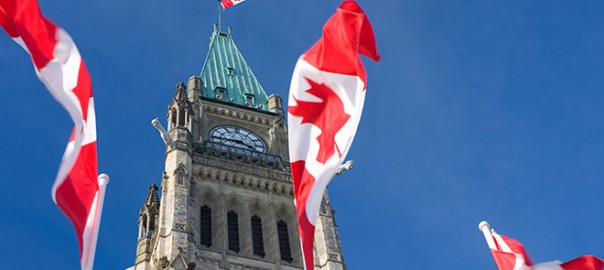 Canadian flags waving by Parliament's Peace Tower