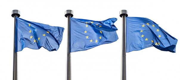 Three European Union flags waving on poles