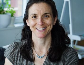 Smiling woman in office wearing a necklace
