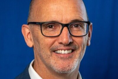 Smiling bald man wearing glasses and suit